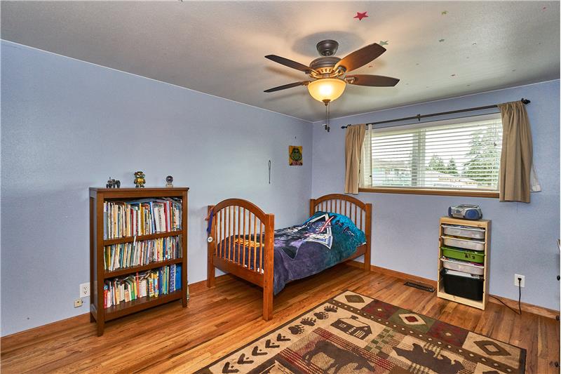 Generous Sized Upstairs Bedrooms with Gleaming Hardwood Floors, Ceiling Fans and Vinyl Window.