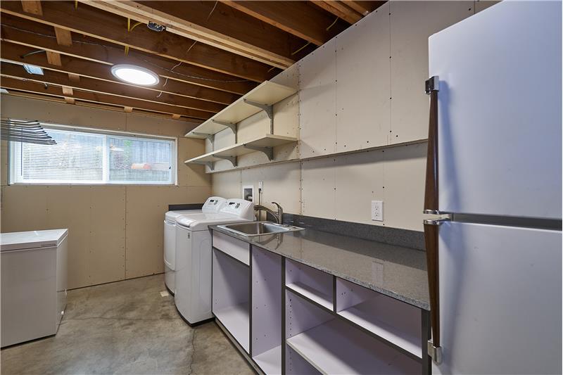 Huge Downstairs Utility Room with new Hot Water Tank. W/D stay with sink and cabinets.