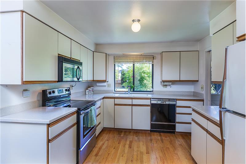 Open Kitchen with Hardwood Floors and Corian Type of Counter Tops.
