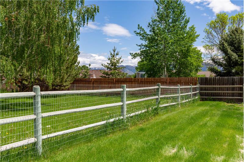 Large fenced backyard with mountain peek